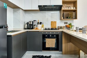 Een moderne keuken met een inbouwoven, een koffiezetapparaat en een magnetron.