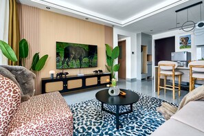 A modern living room with a sofa, a coffee table, and a TV mounted on the wall. - The Big Five with Sunrise and Stunning Panoramic Night Views (Nairobi)
