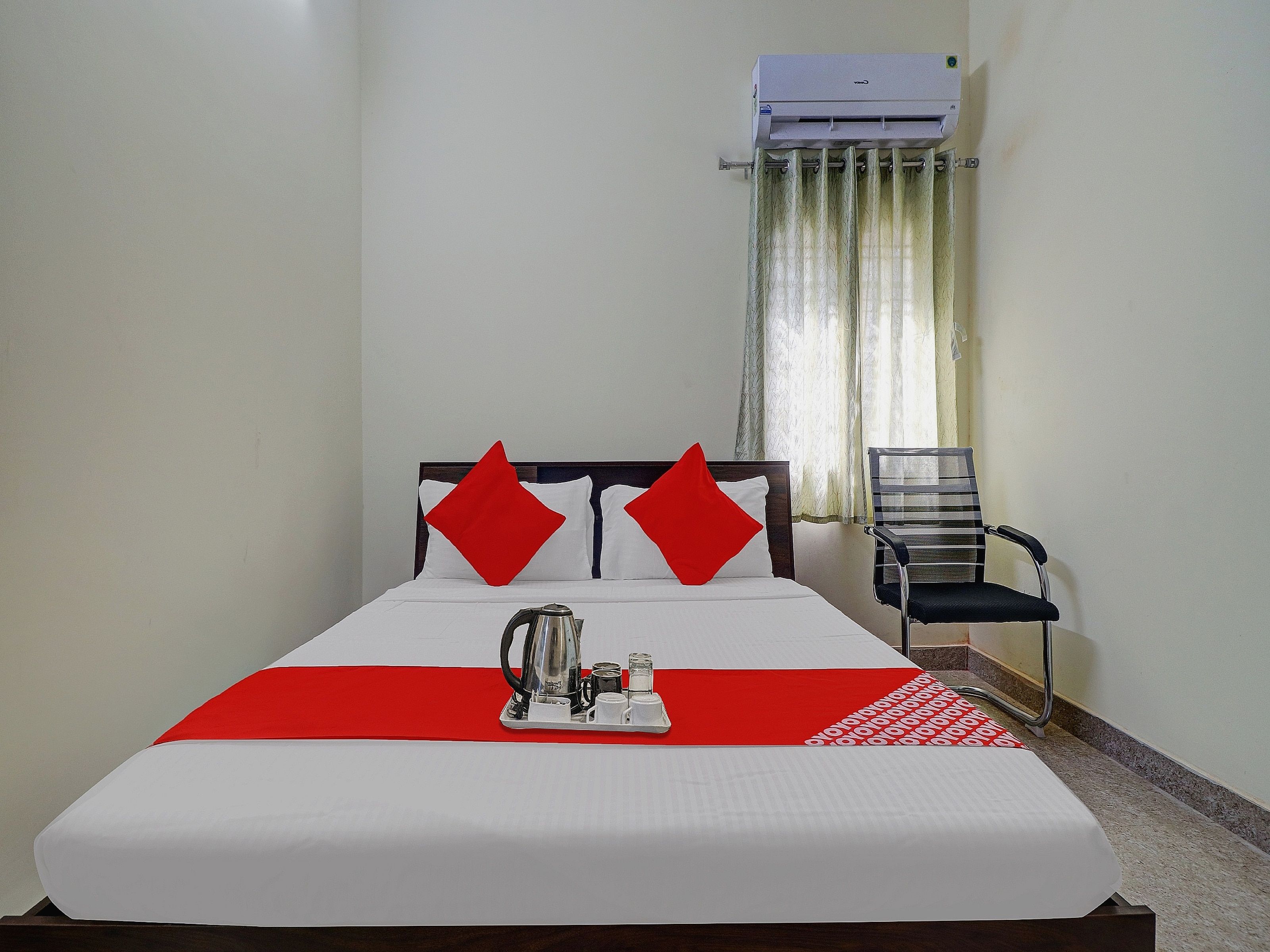 Una habitación de hotel con una cama, una cafetera y una silla.