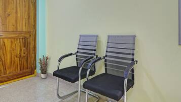 A room with two office chairs, a wooden door, and a small potted plant.
