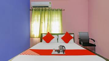 Una habitación de hotel con cama, una silla, cafetera y aire acondicionado.