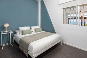 Une chambre moderne avec un lit, une table de chevet et une fenêtre donnant sur un beau paysage.