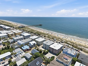 An aerial view of a coastal area with buildings, a beach, and a pier. - Oceanfront Views, Beach Steps Away, Walk Everywhere by Tybee Cottages (Tybee Island)
