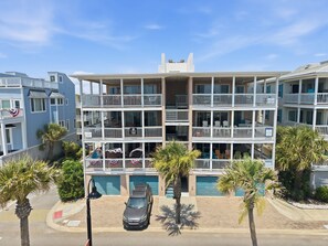 A multi-story building with balconies, a car parked in front, and palm trees. - Oceanfront Views, Beach Steps Away, Walk Everywhere by Tybee Cottages (Tybee Island)