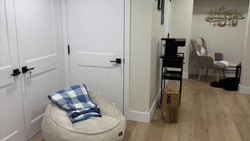 Une pièce comprenant un fauteuil en forme de sac de haricots, une petite table et une étagère fixée au mur.