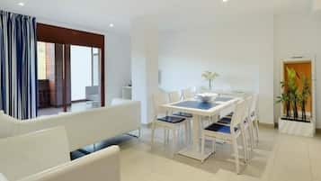 Un comedor moderno con una mesa, sillas, un sofá y una planta en maceta.
