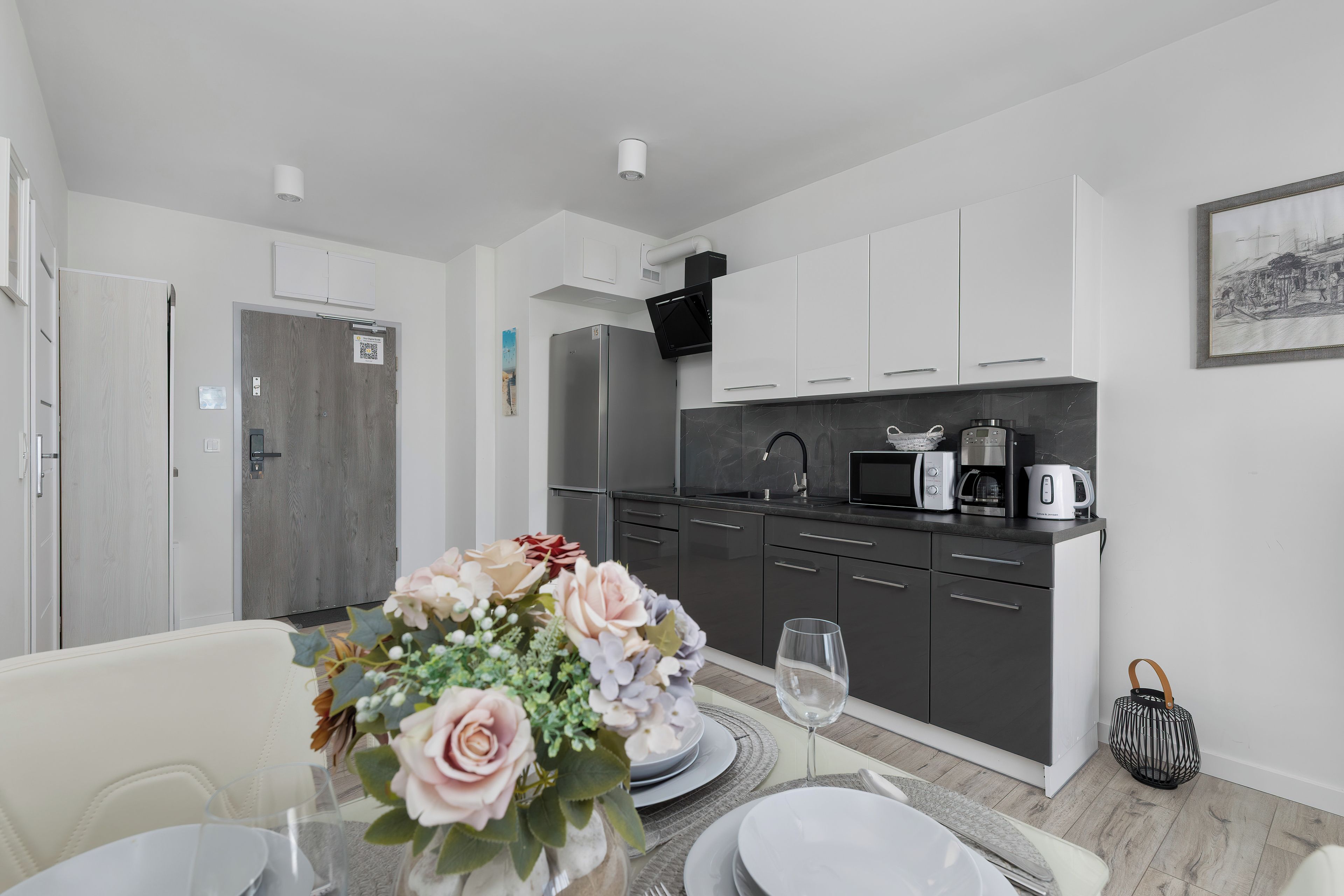 A modern kitchen with dark cabinets, a microwave, and a coffee maker.