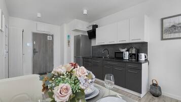 A modern kitchen with dark cabinets, a microwave, and a coffee maker.