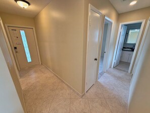 A hallway with a door leading to a kitchen area. - 3BR Hallandale Beach House, Fenced Yard & BBQ, Sleeps 8, Free Parking (Hallandale Beach)