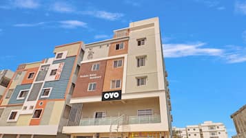 A multi-story residential building with a sign for 'Venkata Ratna Residency' and 'OYO' hotel.