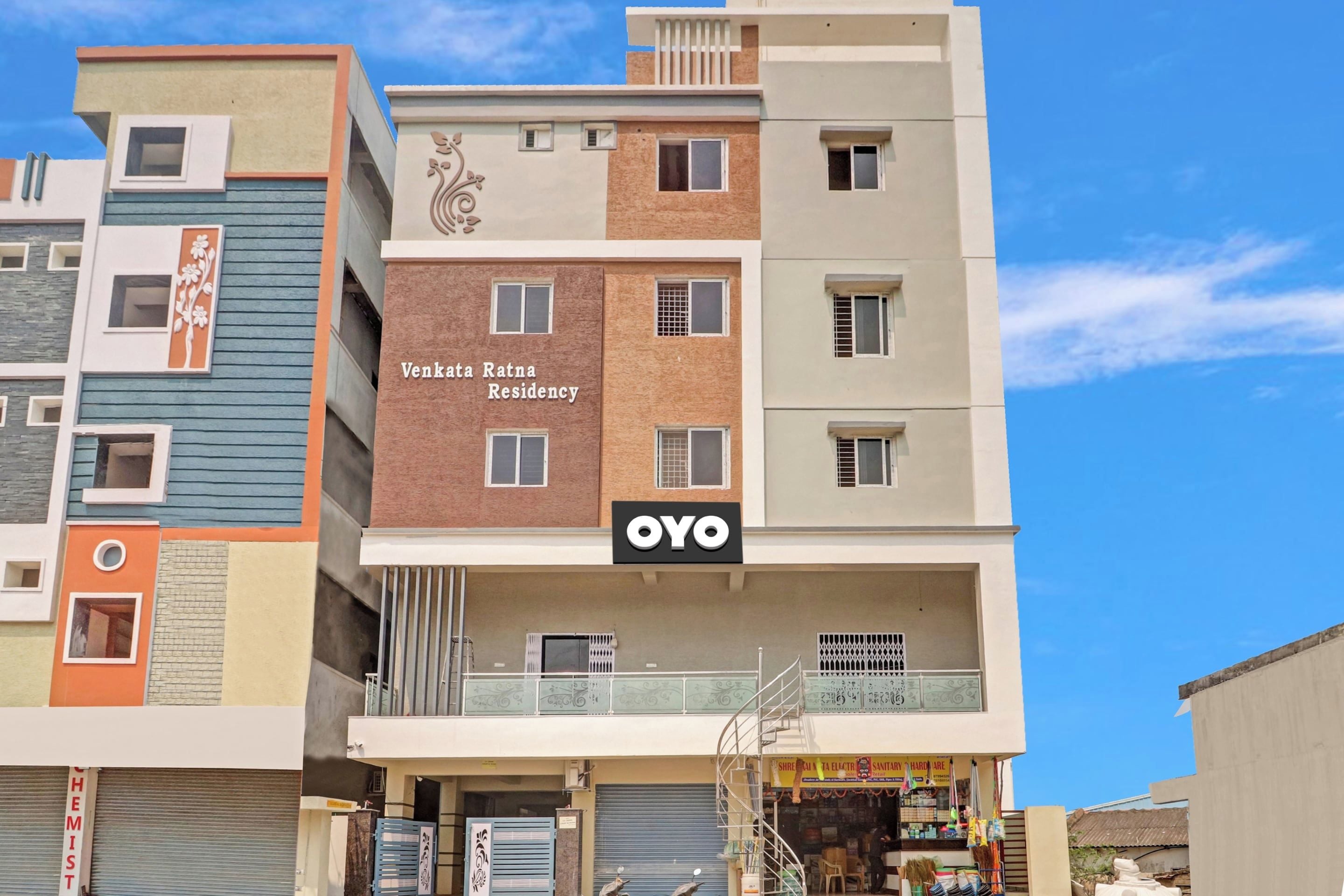 Un edificio de varios pisos con un letrero que indica 'Venkata Ratna Residency' y una tienda llamada 'OYO' en la planta baja.