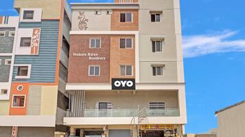 Un edificio de varios pisos con un letrero que indica 'Venkata Ratna Residency' y una tienda llamada 'OYO' en la planta baja.