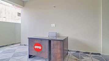 A reception desk with a logo, a chair, and a tiled floor.
