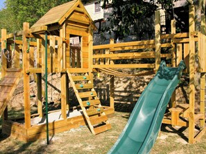 A wooden playground structure with a slide, climbing steps, and a small shelter. - Tuscan casale with hot tub, pool and valley views (Sillico)
