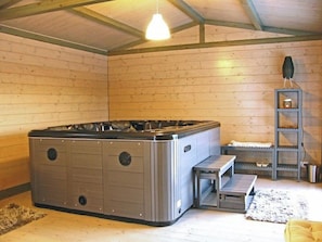 A hot tub in a room with wooden walls and a sloped ceiling. - Apartment with Jacuzzi and pool on Tuscan hilltop (Sillico)