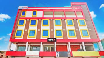 A multi-story hotel building with a sign for 'Hotel Stayo' and 'NLR Plaza' on the facade.