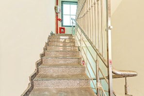 A staircase with metal railings and a fire alarm box at the top.