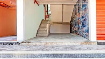 A staircase leading to an upper floor with a red fire extinguisher on the wall.