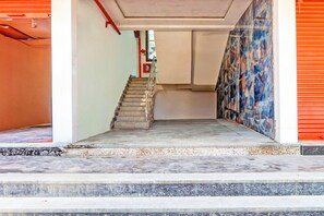 A staircase leading to an upper floor with a red fire extinguisher on the wall.