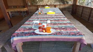 Una larga mesa de comedor con mantel estampado, rodeada de sillas de madera.