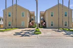 A symmetrical building complex with a central courtyard, featuring a central tree and a small garden. - Cozy 2BR Condo w/shared POOL & Close to Beach! (South Padre Island)