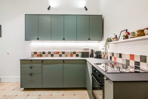 Een moderne keuken met een centraal eiland, inbouwkeuken en een betegelde achterwand.