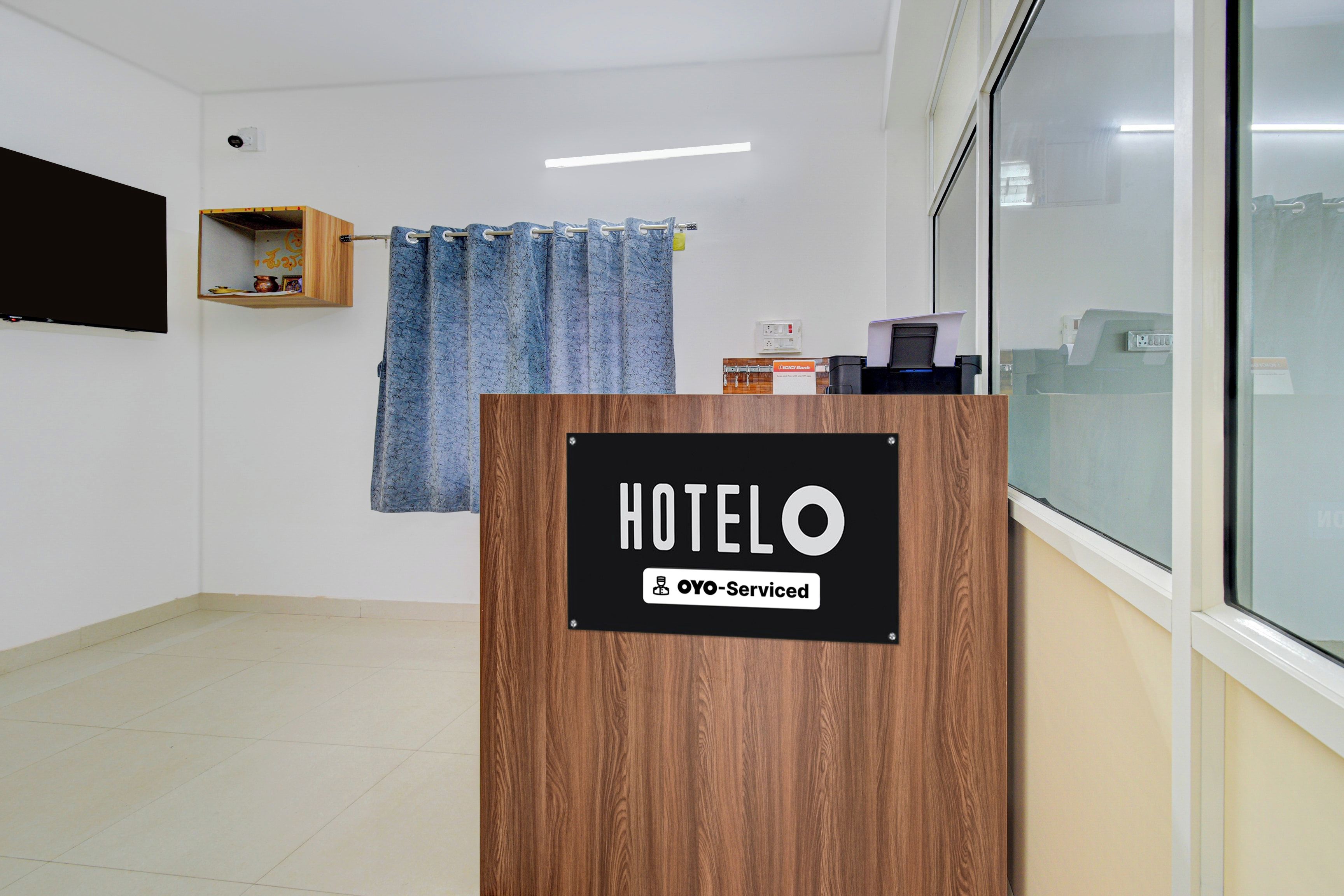 A hotel reception desk with a sign indicating it is serviced by OYO.