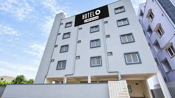 A modern hotel building with a sign indicating it is 'HOTEL 5o-Serviced'.
