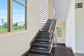 Una escalera con barandilla, una ventana y una señal de salida.