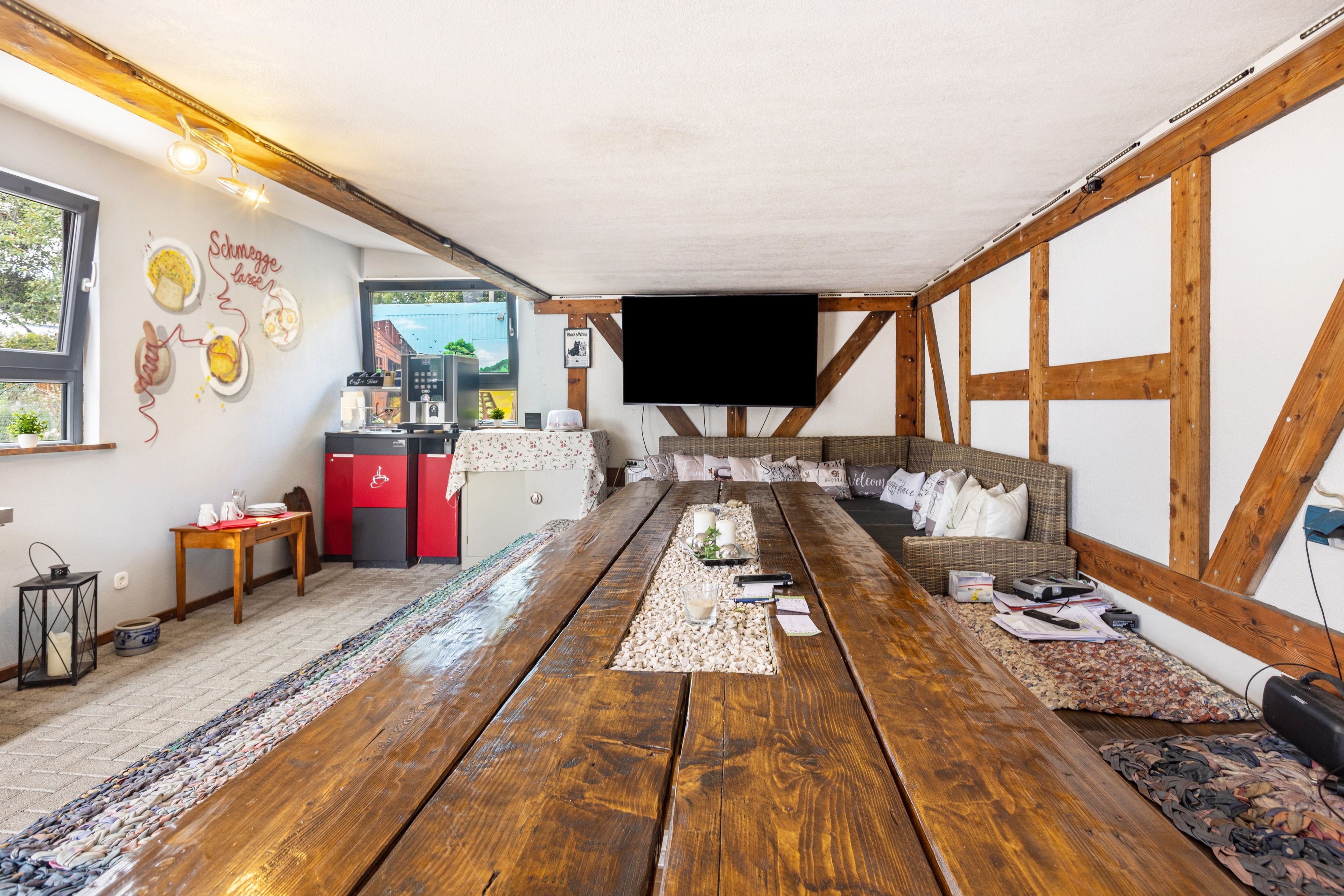 Un intérieur rustique avec une table en bois, un coin salon et une machine à café.