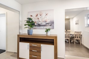 A modern kitchen with wooden cabinets, a countertop, and a dining area with chairs and a table. - Room 'Doppelzimmer 10' with Shared Garden and Wi-Fi (Stadtallendorf)