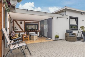 A patio area with a seating arrangement, a table, and a potted plant. - Room 'Einzelzimmer 8' with Shared Garden and Wi-Fi (Stadtallendorf)