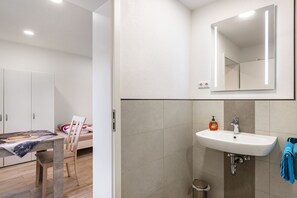 Ein modernes Badezimmer mit Waschbecken, Spiegel und Toilette.