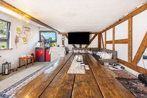 A rustic interior with a wooden table, seating area, and a coffee machine. - Room 'Einzelzimmer 9' with Shared Garden and Wi-Fi (Stadtallendorf)