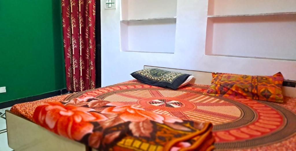 Un letto con una coperta a motivi, un cuscino e un cuscino decorativo su uno scaffale a parete.
