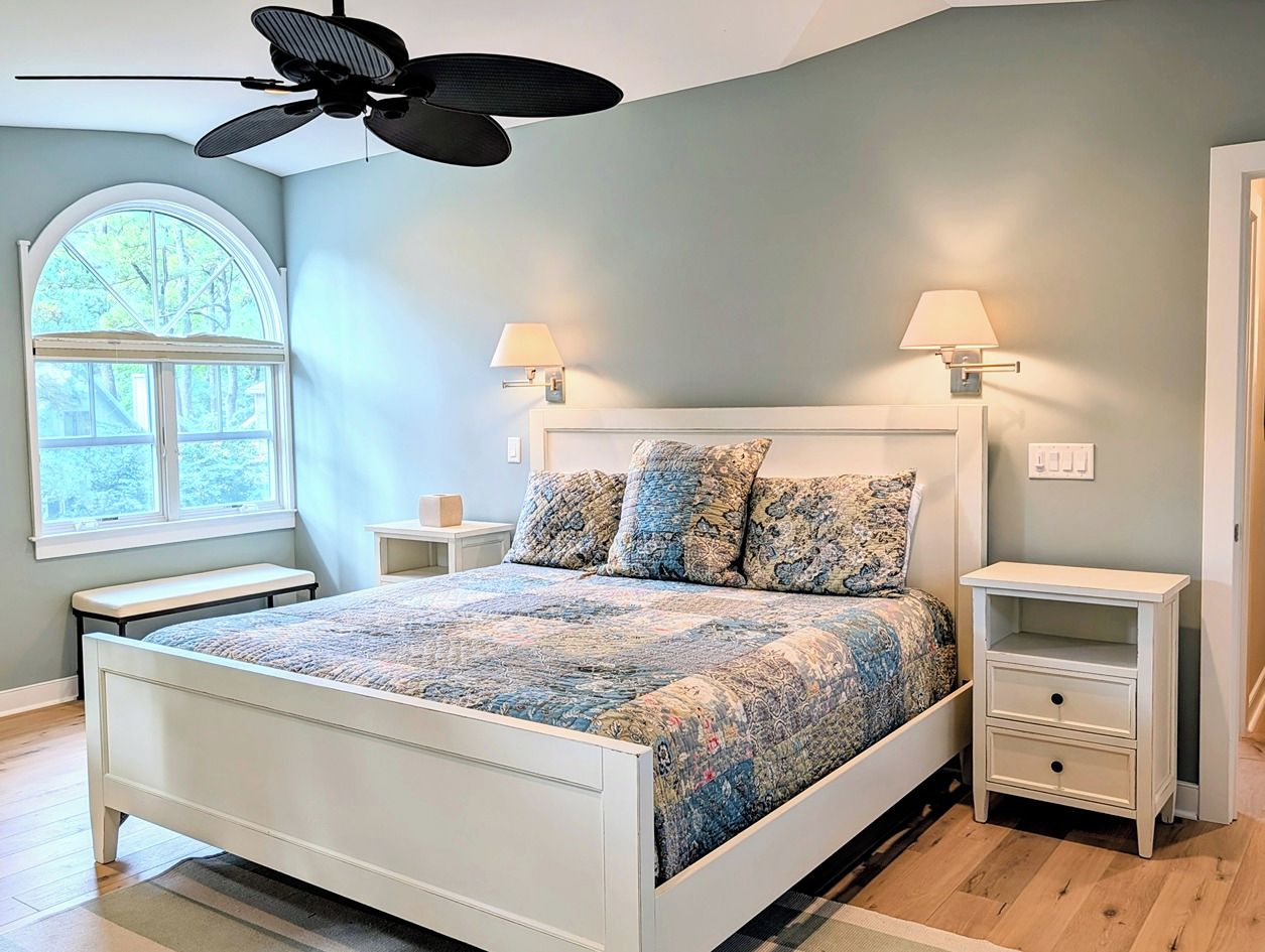 A bedroom with a bed, two bedside tables, a ceiling fan, a window, and a nightstand with a lamp. - South Bethany Home. Walk to Private Beach. Screened Porch & Outdoor Shower (South Bethany)
