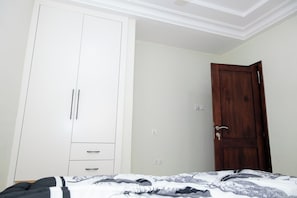 Un dormitorio con una cama, un armario y una puerta de madera.