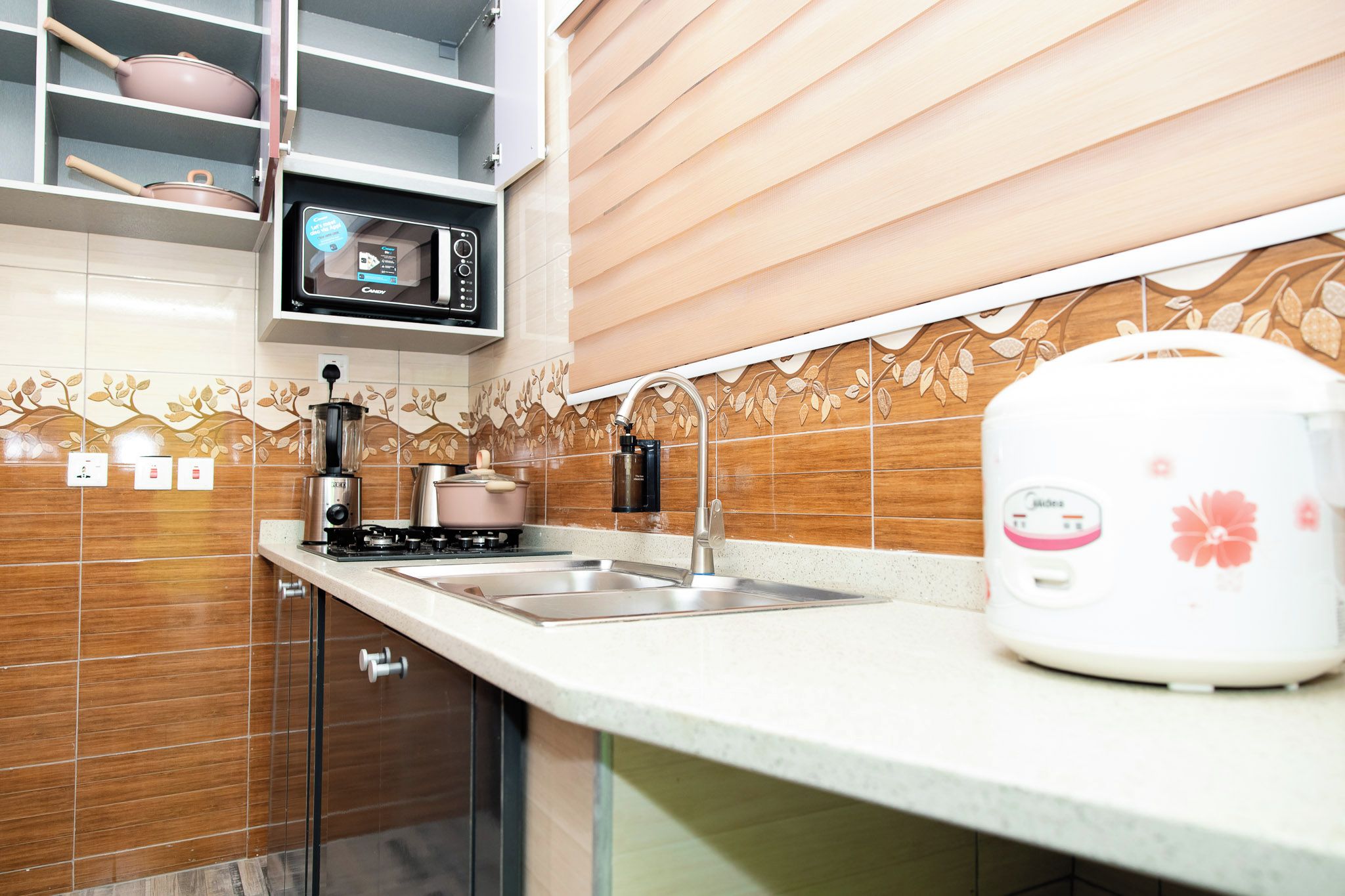A kitchen with a microwave, stove, sink, and a coffee maker.