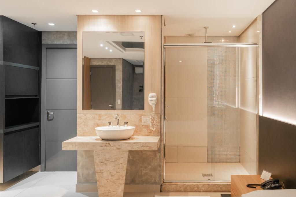 Een moderne badkamer met een grote spiegel, een wastafel en een douche.