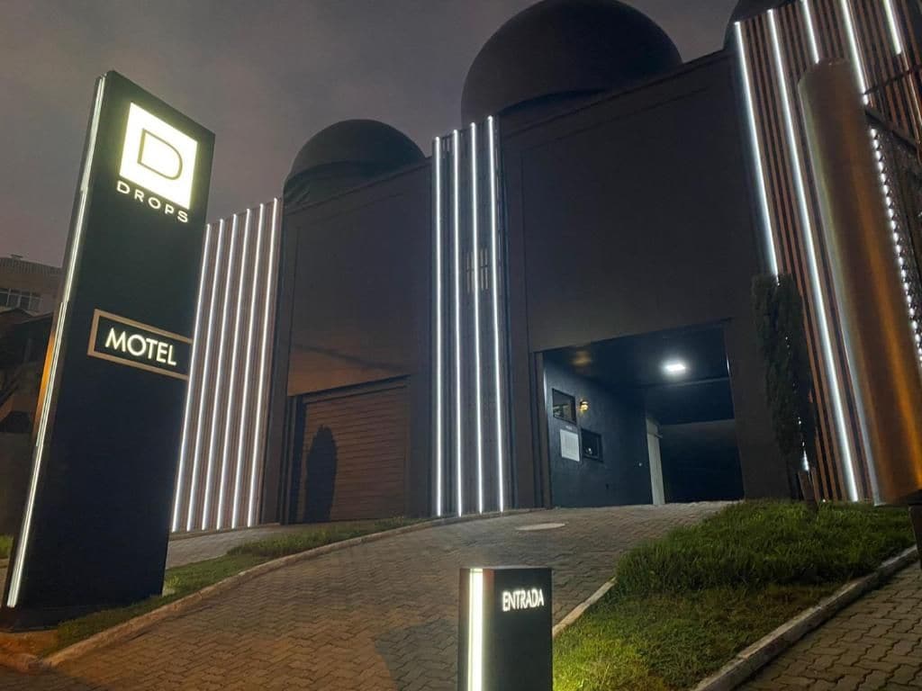 Entrada moderna d'un motel amb un cartell destacat, una calçada asfaltada i una façana ben il·luminada.