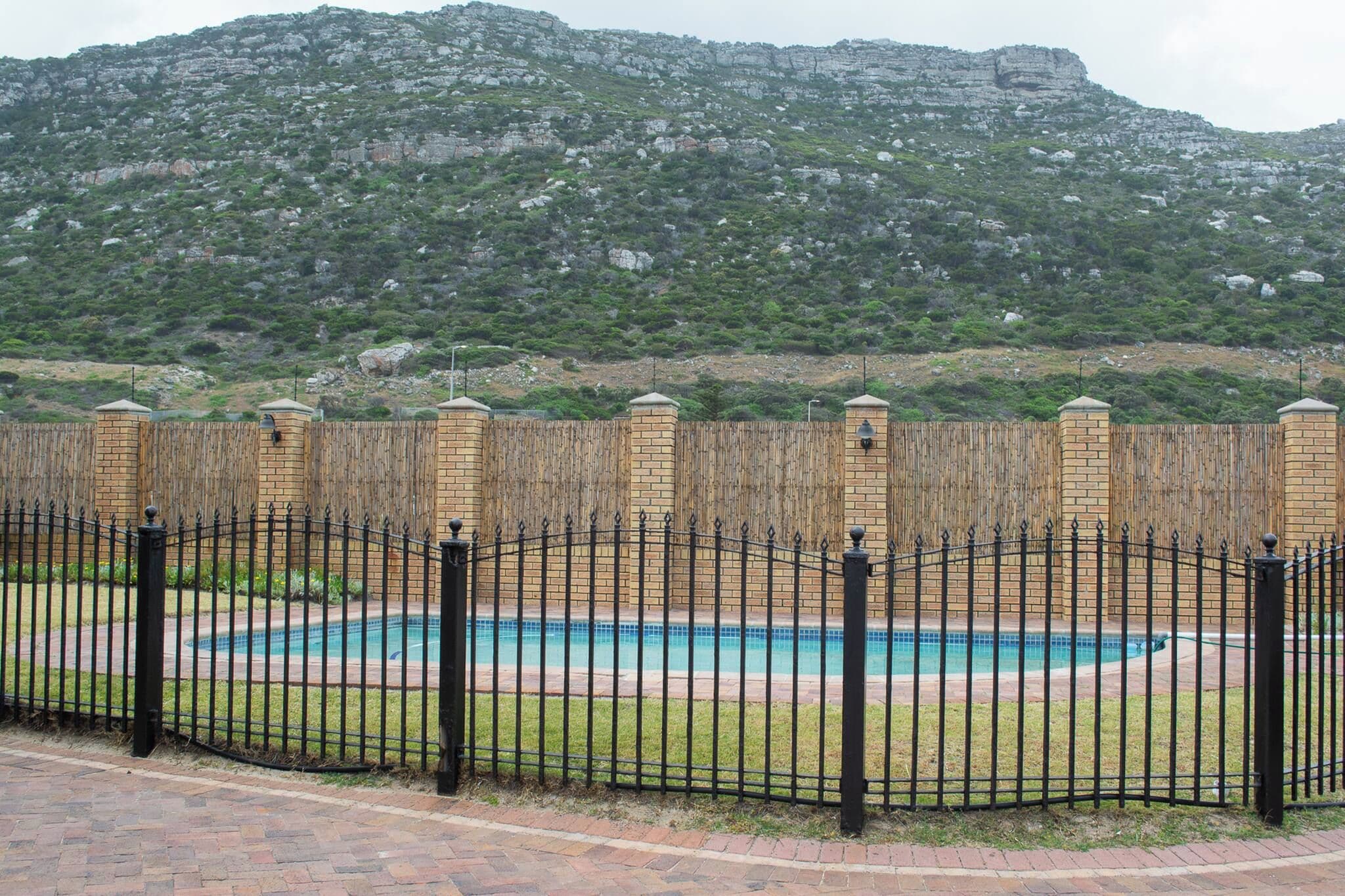 Área de piscina cercada com montanhas ao fundo.