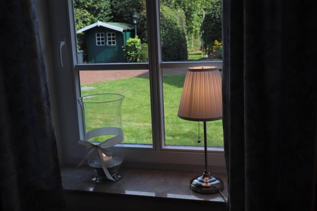 Ein Fenster mit einer Lampe und einem Glasobjekt auf dem Fensterbrett.