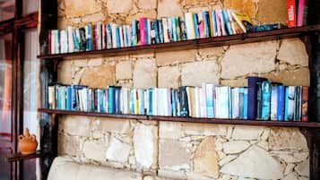Una estantería llena de libros frente a una pared de piedra.
