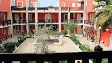 A courtyard with a central garden, surrounded by multi-story buildings with balconies.