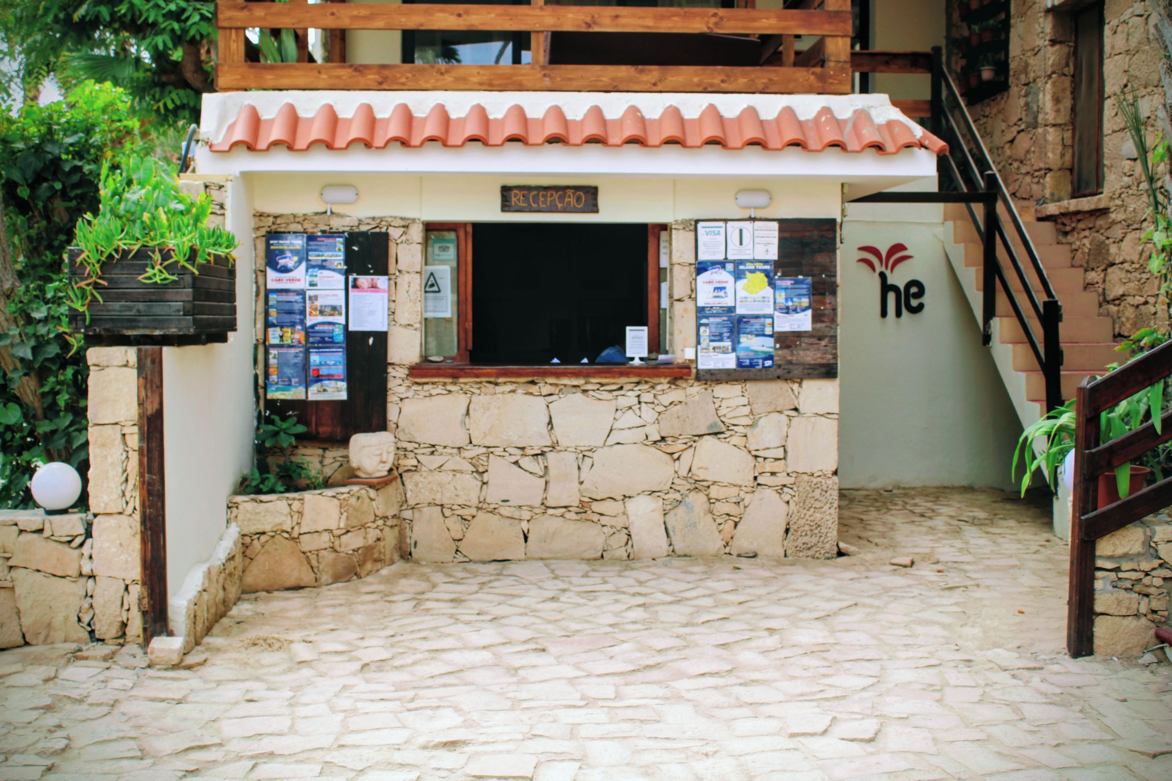 Ein Steinhaus mit Ziegeldach, einer Rezeption und verschiedenen Aushängen.