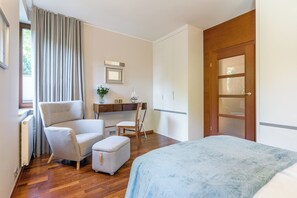 A bedroom with a bed, a chair, a desk, and a wardrobe. - Imperial Apartments - Haffnera Residence (Sopot)