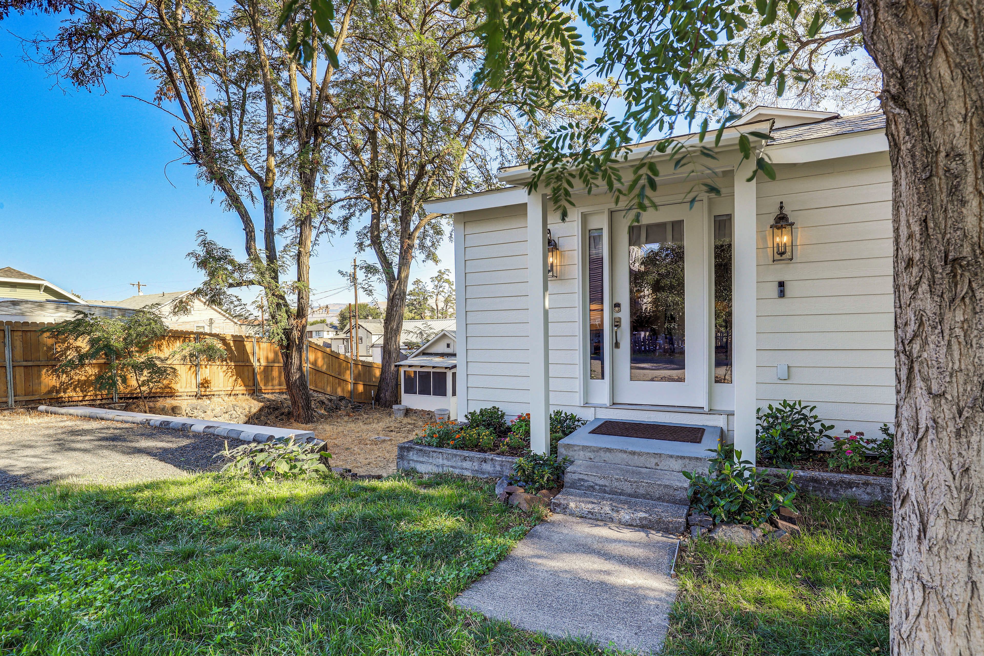 A residential property with a front porch, a small garden, and a wooden fence.