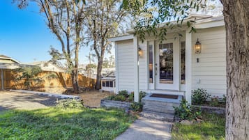 A residential property with a front porch, a small garden, and a wooden fence.