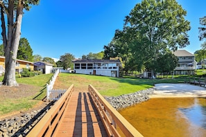 A wooden bridge leading to a house with a pond, surrounded by trees and a white fence. - Private Dock & Lake Norman Access! Family Home (Mooresville)