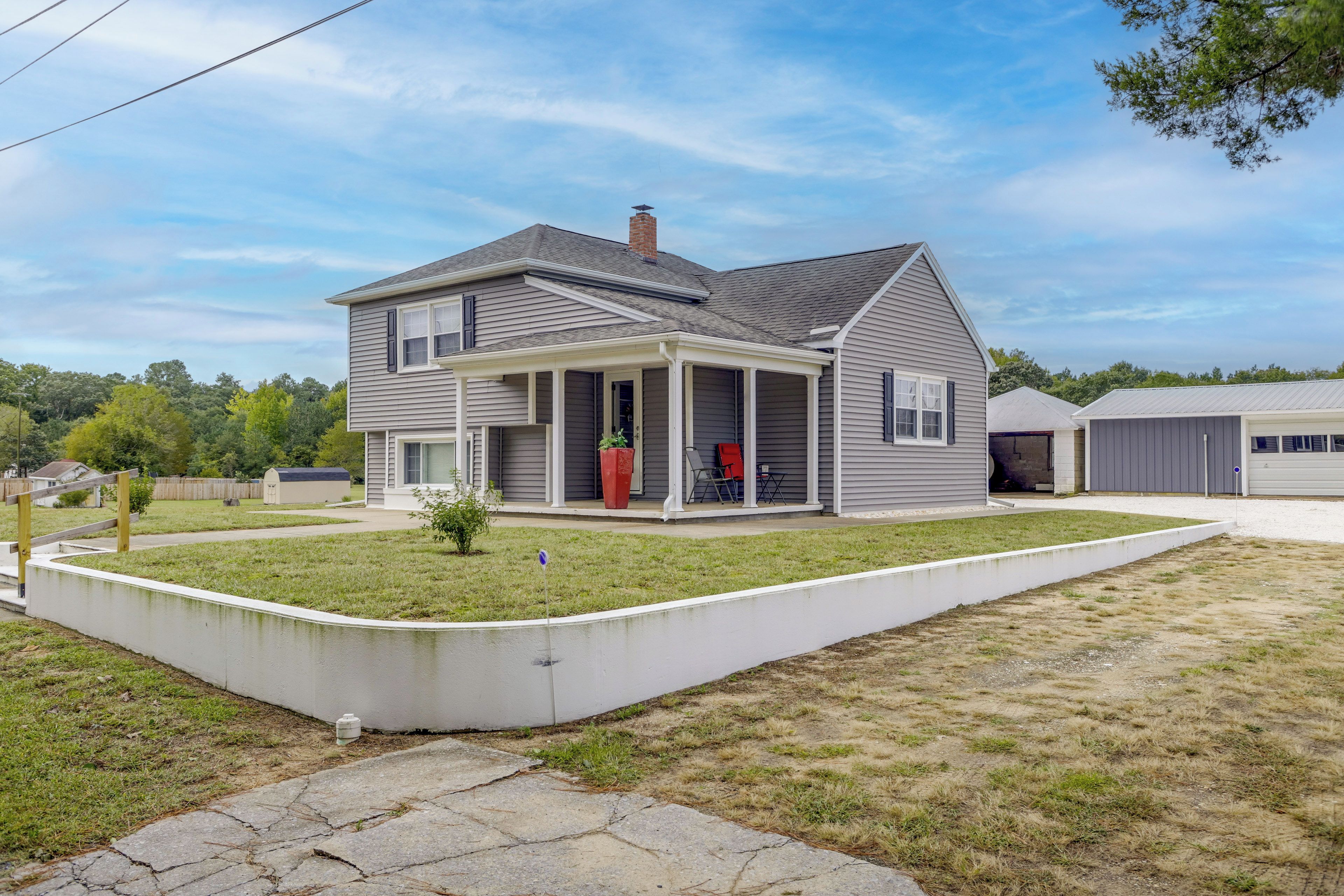 A two-story residential house with a covered porch, a garage, and a well-maintained lawn.
